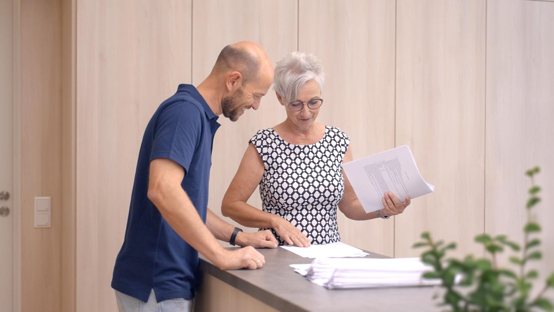 Eine Lehrkraft und eine Schulsekretärin betrachten Formulare