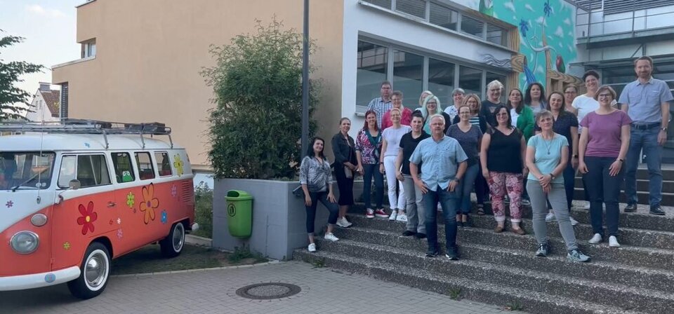 Die Eltern der Schulpflegschaft stehen auf einer Treppe vor dem Schulgebäude