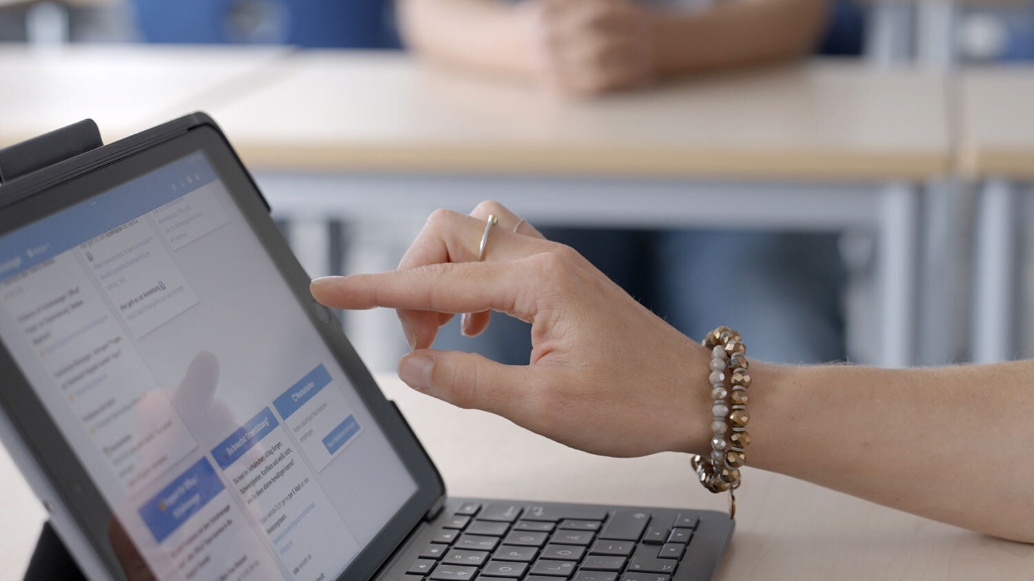 Eine Hand bedient auf einem Tablet ein Software-Programm