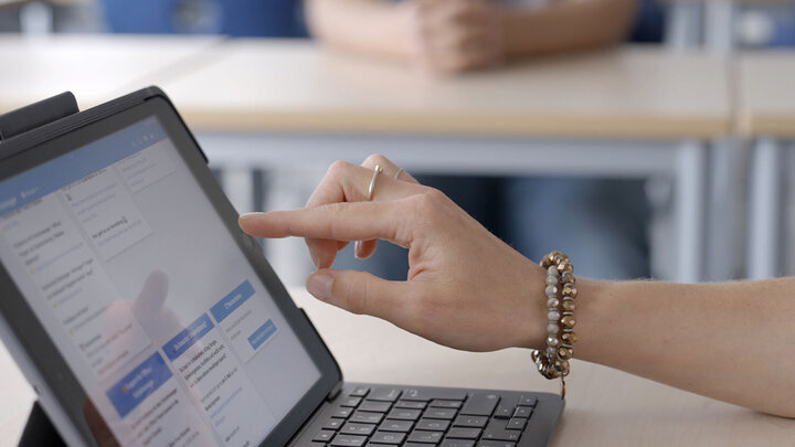 Eine Hand bedient auf einem Tablet ein Software-Programm