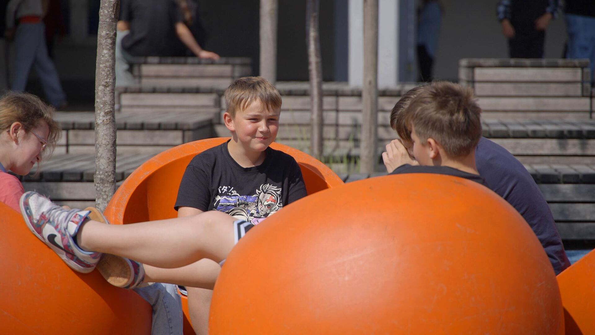 Schüler sitzen in der Pause im Schulhof und unterhalten sich