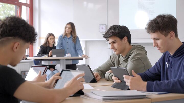 Schüler sitzen vor dem Tablet in einem Unterricht