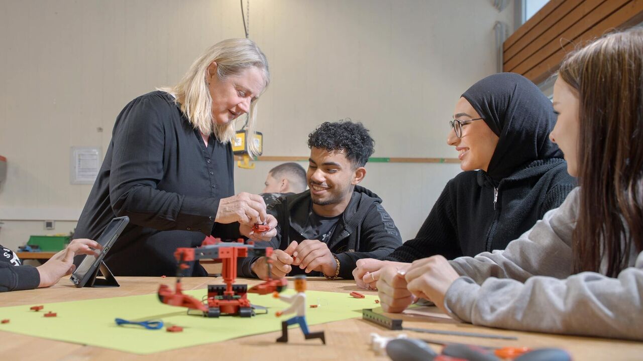 Eine Lehrerin erklärt den Schülerinnen und Schüler etwas Unterricht