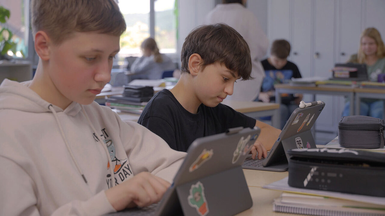 Schüler sitzen vor dem Tablet