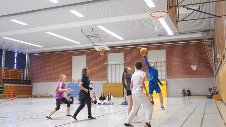 Schulklasse in der Sporthalle beim Basketball