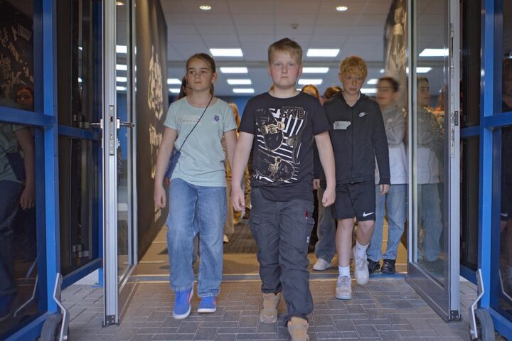 Schülerinnen und Schüler gehen durch einen Flur