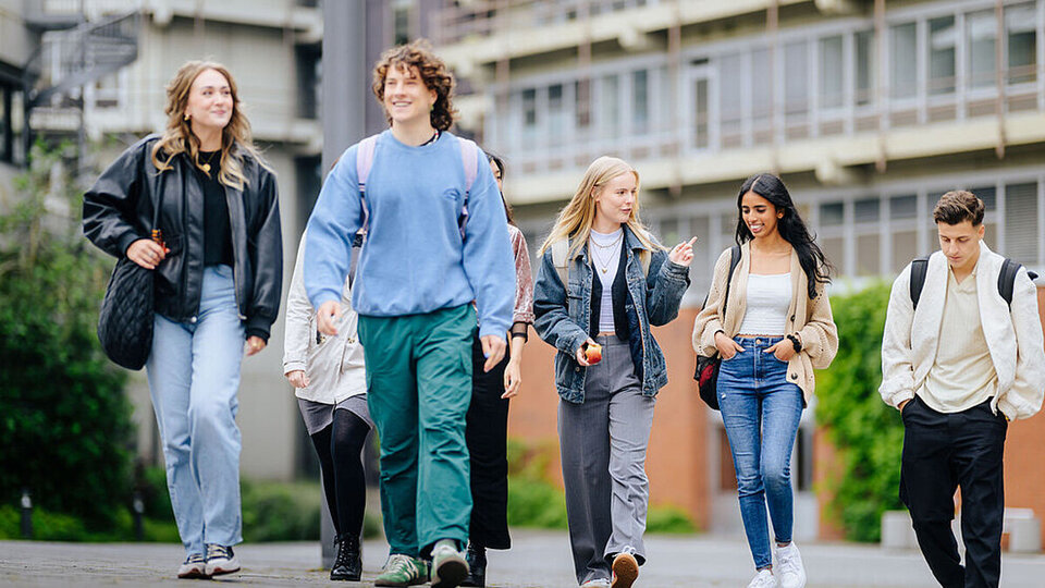 Studenten und Studentinnen laufen über den Campus der Universität in Paderborn