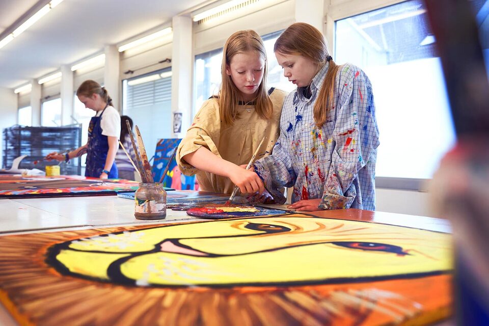 Schülerinnen beim Malen im Kunstunterricht