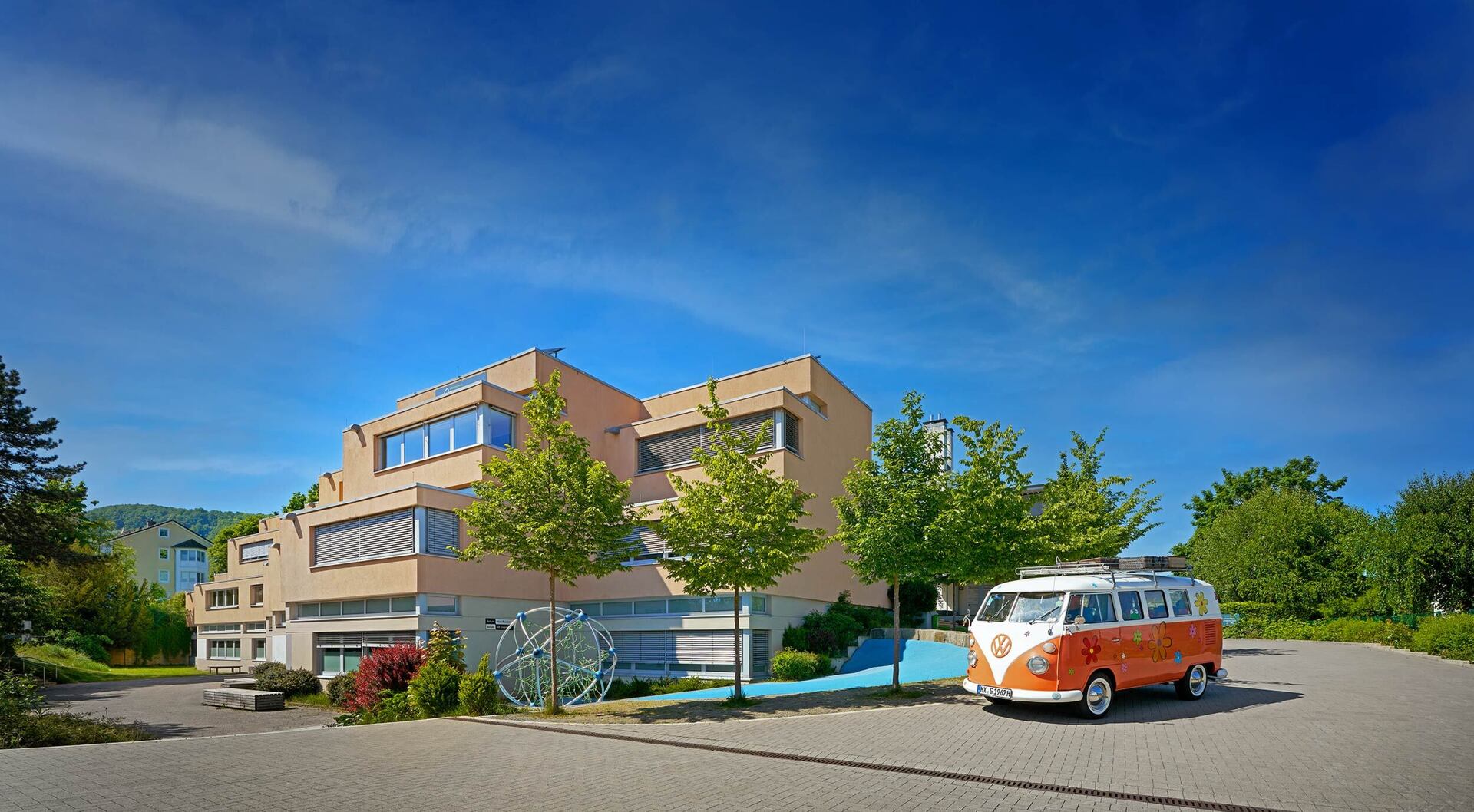 Gebäudeansicht mit dem Schulbulli am Standort Geschwister-Scholl-Straße